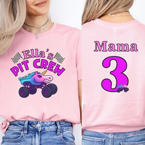 Puede incluir: Camiseta rosa con el gr&aacute;fico "Ella's Pit Crew" con un cami&oacute;n monstruo unicornio. La parte trasera de la camiseta dice "Mama 3" con un gr&aacute;fico de cami&oacute;n unicornio a juego. La camiseta es de material suave.