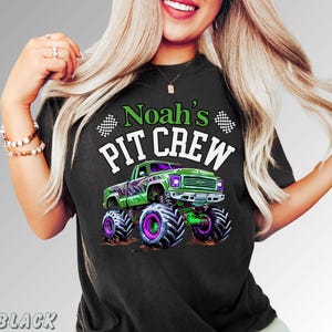 Pode incluir: Camiseta preta com um gr&aacute;fico de um monster truck verde e roxo. O texto "Noah's PIT CREW" est&aacute; acima do caminh&atilde;o. Bandeiras quadriculadas em ambos os lados do texto.