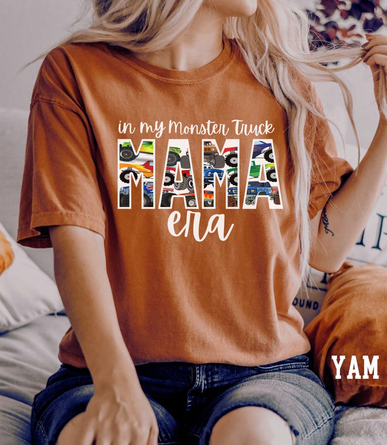 Puede incluir: Una camiseta marr&oacute;n con el texto "in my monster truck mama era" impreso en ella. El texto est&aacute; formado por im&aacute;genes de monster trucks.