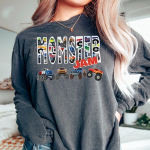 May include: A dark gray sweatshirt with the words "Momster Jam" printed on the front. The words are made up of images of monster trucks.