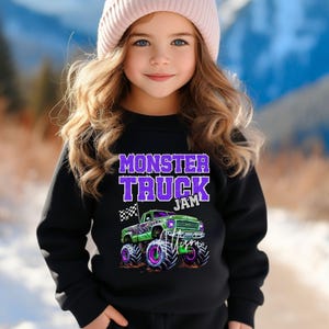 May include: A black sweatshirt with a purple "Monster Truck Jam" graphic and a green monster truck with purple accents.