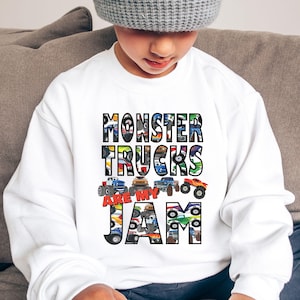 Puede incluir: Sudadera blanca con un dise&ntilde;o gr&aacute;fico de camiones monstruo. El texto dice "Monster Trucks Are My Jam".