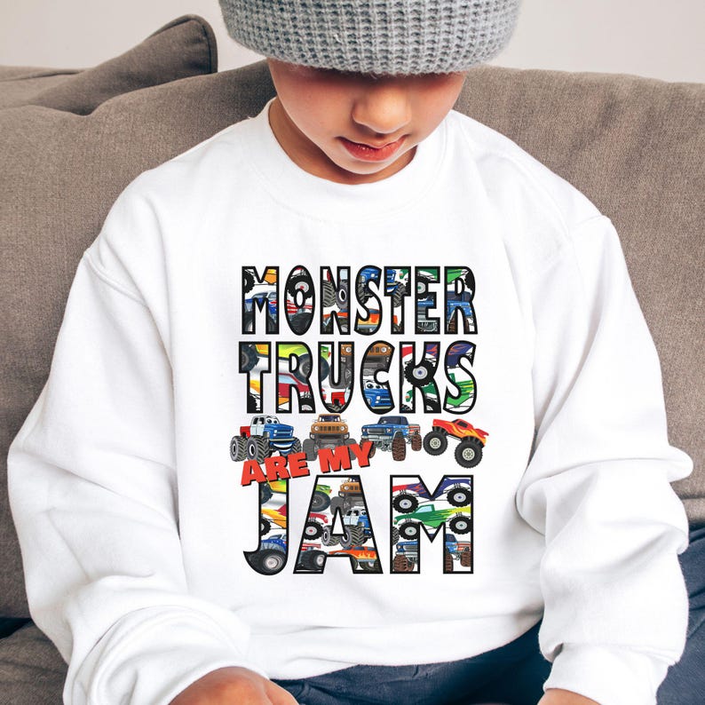 Puede incluir: Sudadera blanca con un dise&ntilde;o gr&aacute;fico de camiones monstruo. El texto dice "Monster Trucks Are My Jam".