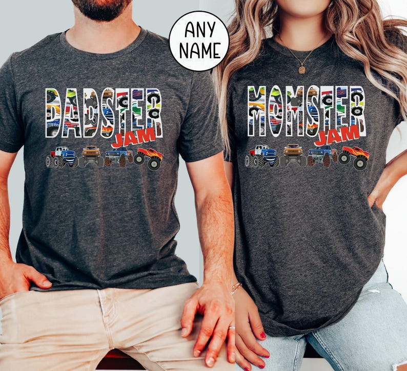 May include: Two gray t-shirts with a monster truck theme. The shirt on the left says "DADSTER JAM" and the shirt on the right says "MOMSTER JAM". Both shirts feature a line of monster trucks with colorful designs.