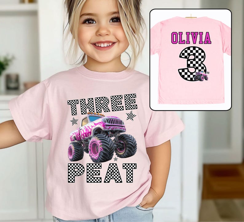Pictured is a young girl wearing a pink shirt which says THREE PEAT in black and white checkered letters along with a big graphic of a pink monster truck and checked stars and flag. On the back of this tee is custom name OLIVIA in purple and custom number (Age) 3 which is also checkered