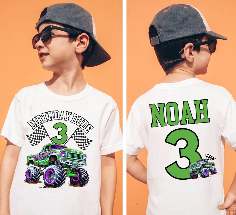 Pictured is a young boy wearing a natural colored comfort colors t-shirt with a front back print design theme. the front says BIRTHDAY DUDE and the number 3 with a purple and green Hot cars wheels monster truck theme and 2 checkered flags. the back has custom name NOAH and a big number 3 in green and a small version of the monster truck