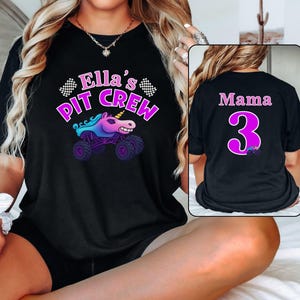 Puede incluir: Camiseta negra con el texto "Ella's PIT CREW" en rosa y morado, con un gr&aacute;fico de un cami&oacute;n monstruo unicornio. La parte trasera de la camiseta tiene "Mama" y el n&uacute;mero "3" en rosa, con un peque&ntilde;o gr&aacute;fico de cami&oacute;n monstruo.