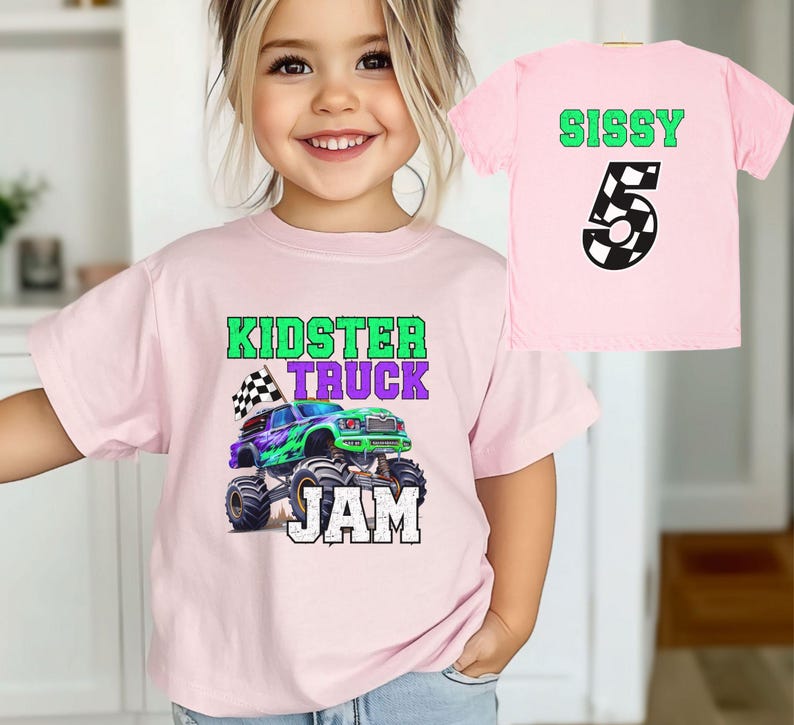 Puede incluir: Camiseta rosa con un gr&aacute;fico de cami&oacute;n monstruo verde, morado y negro y el texto "Kidster Truck Jam". Una segunda camiseta rosa con el texto "Sissy 5" en verde y negro.