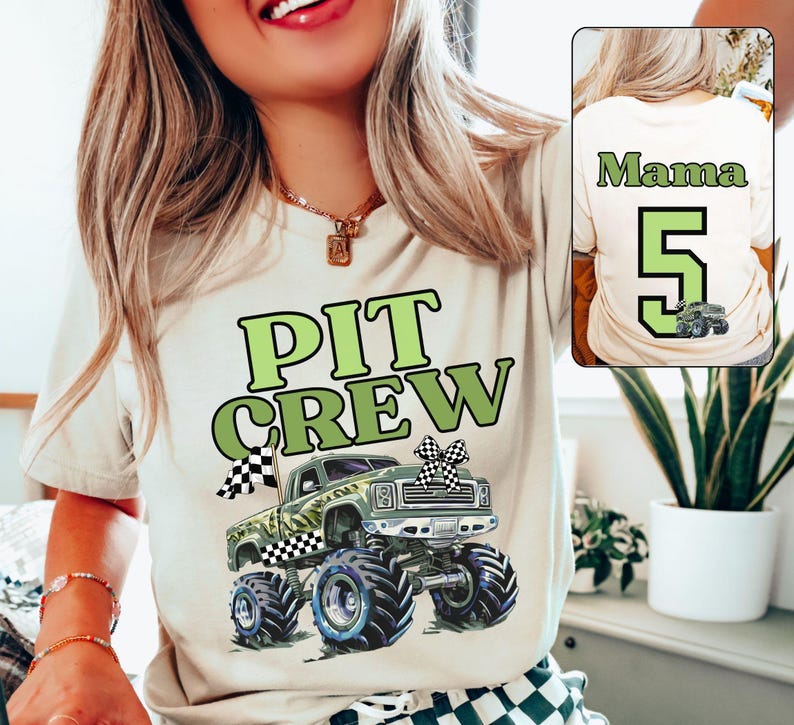 Op de afbeelding: Beige T-shirt met een groene en zwarte monstertruckafbeelding en de woorden "PIT CREW" in het groen. De achterkant van de shirt heeft het woord "Mama", het nummer "5" en een monstertruckafbeelding. Het shirt heeft een ronde hals.