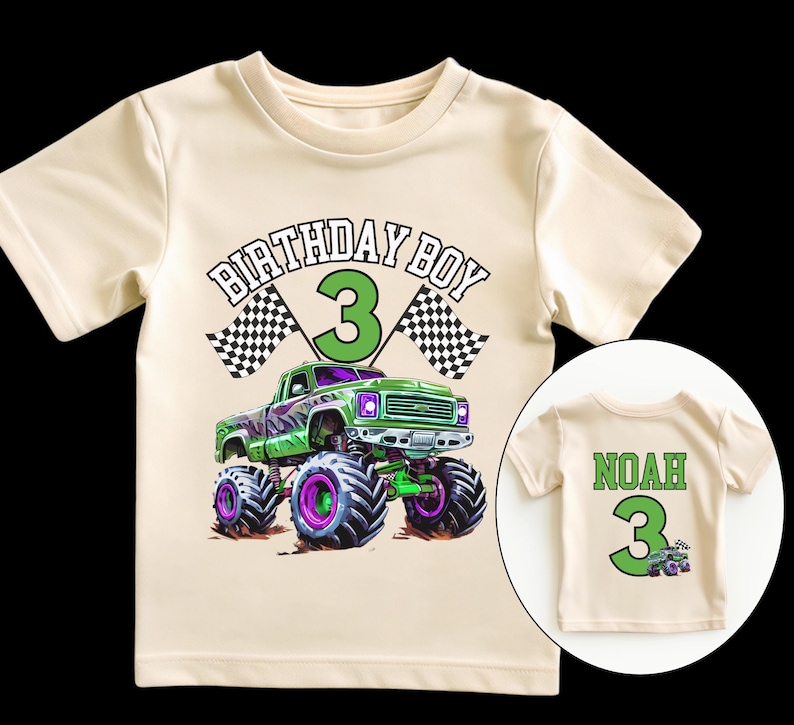 May include: Cream-colored t-shirt featuring a green monster truck graphic with purple and black wheels. The text "BIRTHDAY BOY 3" is above the truck, with checkered flags on either side. A smaller shirt shows the name "NOAH" and the number "3".