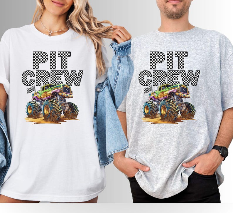 May include: White and gray t-shirts with the text "PIT CREW" above a colorful monster truck graphic. The monster truck has large tires and is in a dirt setting. The shirts are casual wear.
