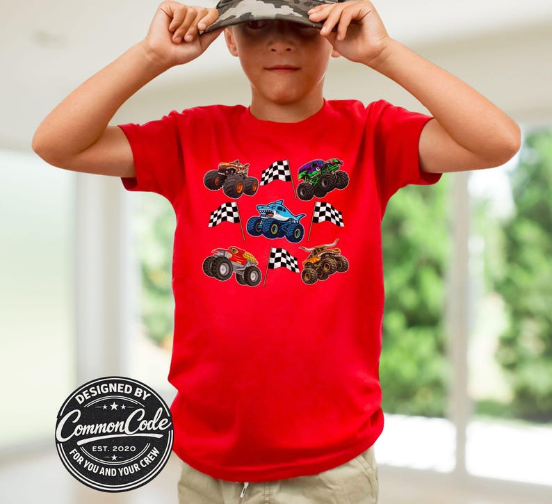 Boy is wearing a red t-shirt with racing monster truck jam theme trucks with checkered racing flags. Very colorful and vibrant colors and vibe. Cool kid tee, perfect for monster truck birthday parties, race day shirt, birthday gift for truck lovers, Christmas gift for boys and men. Perfect Father's day gift of matching dad and son, or matching siblings and boy Mama with son. Adult , teen kids, toddler and baby sizes. Digger, toro bull, tiger shark, blue megalodon, Sparkle Unicorn. Choose design