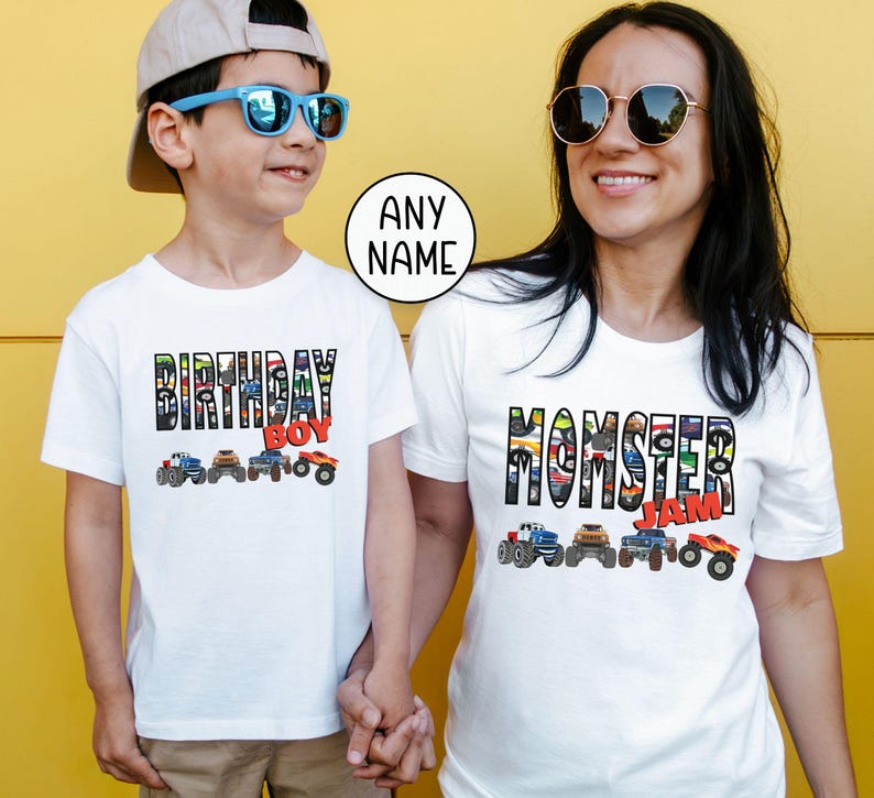 Op de afbeelding: Witte T-shirts met een monstertruckthema. Het shirt voor kinderen zegt "Birthday Boy" met een rij monstertrucks. Het shirt voor volwassenen zegt "Momster Jam" met een rij monstertrucks.
