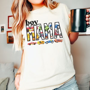 May include: A white t-shirt with the text "boy mama" in black letters. The letters are filled with colorful toy cars.