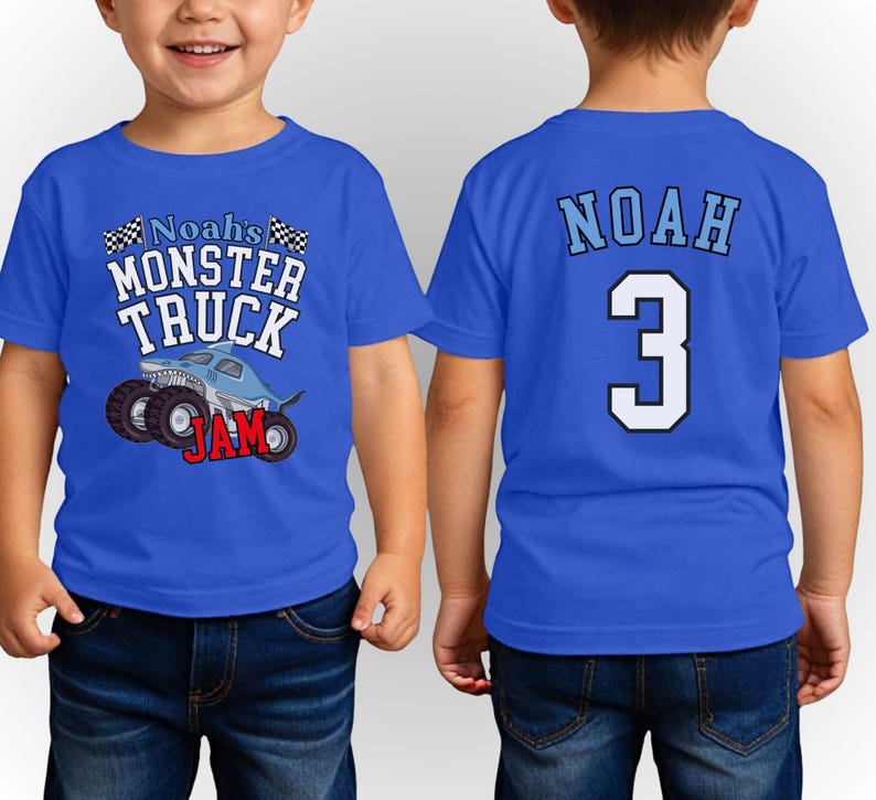 以下が含まれることがあります： モンスター トラックのグラフィックと「Noah's Monster Truck Jam」の文字が前面にプリントされた青い半袖Tシャツ。シャツの背面には「Noah」という名前と数字の「3」があります。