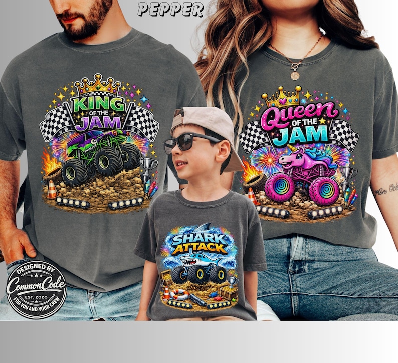 Peut inclure: Trois t-shirts gris avec des motifs de monster trucks color&eacute;s. L'un dit "King of the Jam", un autre "Queen of the Jam", et le troisi&egrave;me "Shark Attack". Les chemises sont port&eacute;es par une famille.