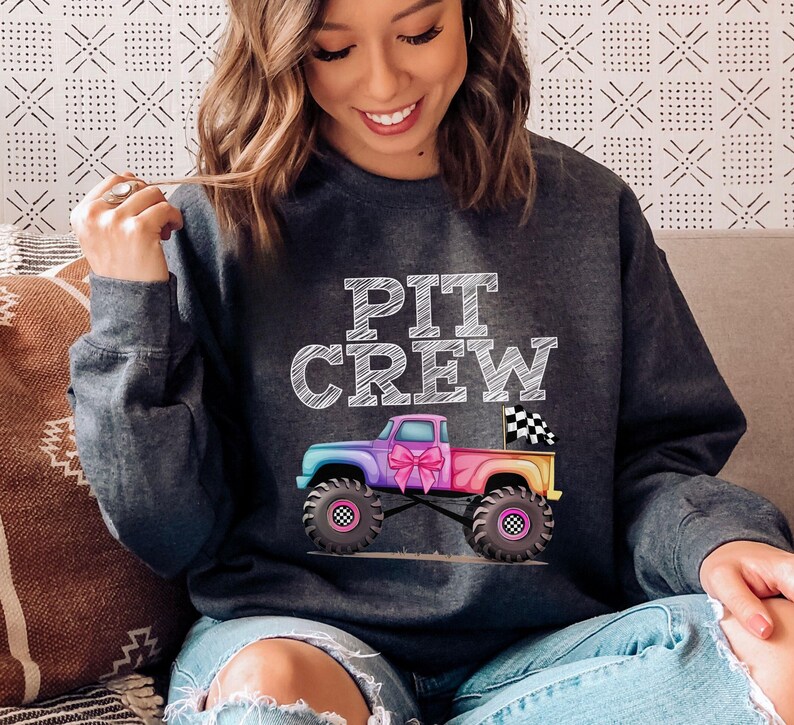 Lady Model is wearing a warm comfy sweatshirt Monster Truck Watercolor rainbow colors female version in pink blue mens boys version in purple and blue  wear it as a family matching or to monster truck jam Mommy Daddy adult child sizes in assorted colors