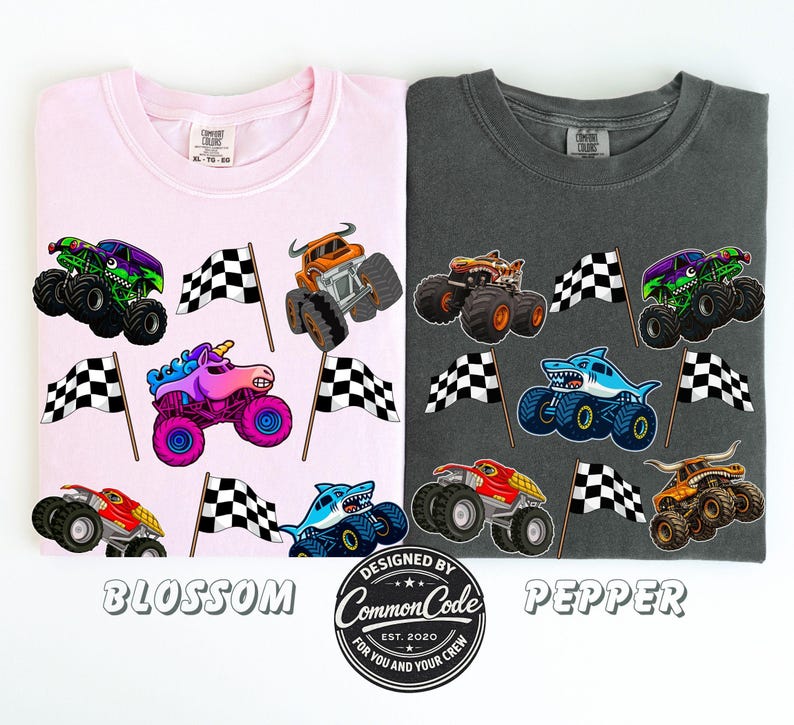以下が含まれることがあります： ピンクと濃いグレーの2枚のTシャツが表示されています。ピンクのシャツには「Blossom」、グレーのシャツには「Pepper」と書かれています。どちらのシャツにも、カラフルなモンスタートラックのグラフィックとチェッカーフラッグが描かれています。