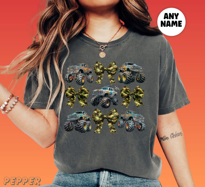 woman wearing a comfort colors pepper vintage shirt with camouflage camo coquette bows and monster trucks in a collage style grid. Perfect for Monster truck show race day, birthday party, gift for Monster truck lover. A girly Tough Girl Power Look and feel. Mommy and Me matching set with personalized optional custom name. Monster truck Girls Night Out group shirt idea, Boy Mama shirt.