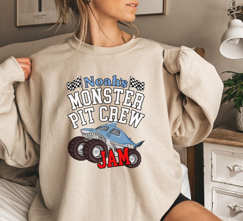 Boys birthday Shark monster truck jam family matching sweatshirts super warm and cozy. Megalodon. Big tires wheels Custom name personalized name black and white checkered flags college varsity letters font. when the time comes for a super cool birthday boy sweatshirt and the weather is cool, this is it. He will love this if he likes monster trucks at all. Great white.