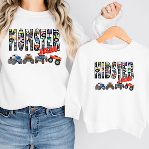 May include: White long-sleeve shirts with a monster truck design. The adult shirt says "Momster Jam" and the child shirt says "Kidster Jam".