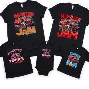 May include: Black t-shirts with monster truck graphics. Designs include "Dadster Jam," "Momster Jam," "Monster Trucks Are My Jam," and "Kidster Jam." The graphics feature red monster trucks with large wheels.