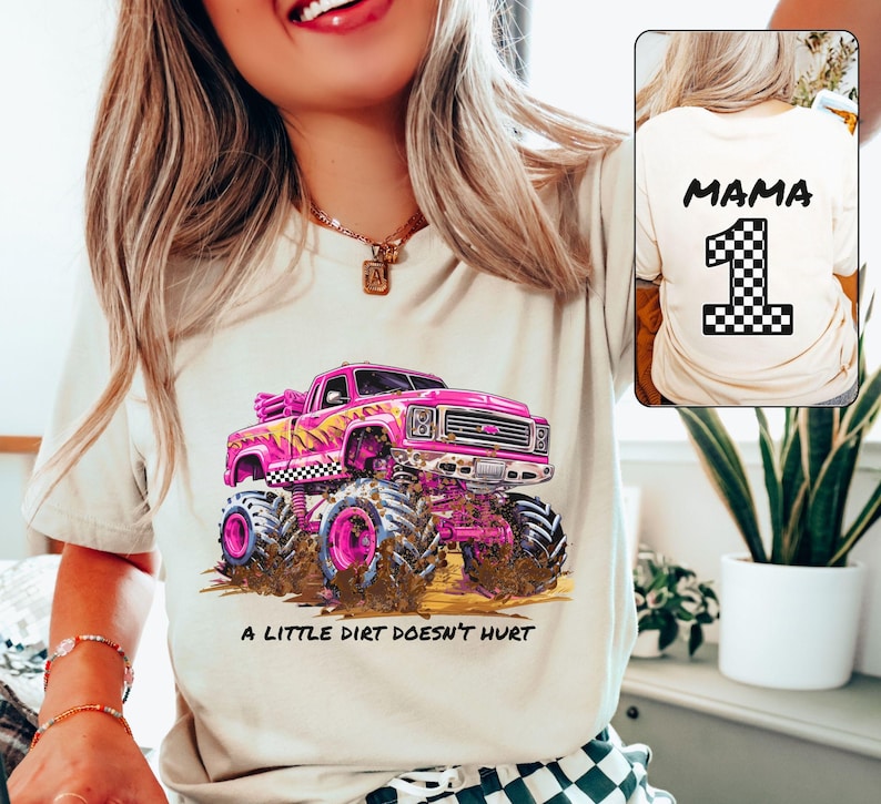Woman Model is wearing a beige natural t-shirt showing the front and back side. The front has a Barbie Pink Monster Truck with black and white checkers. Underneath is a dirt floor with dirt and mud flinging up on the truck. It says "a little dirt doesn't hurt". The back says "Mama" and has a checkered number 1. Custom Name and number Monster Truck Jam Birthday Party Race Day Gift for Mom.