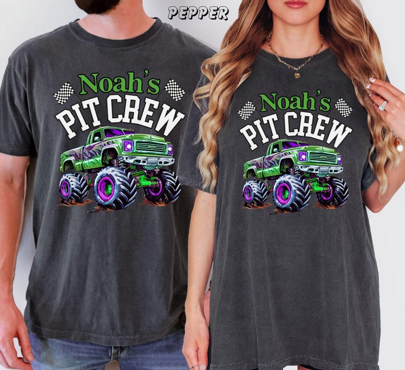 Pode incluir: Duas camisetas cinza escuro com o texto "Noah's PIT CREW" e um gr&aacute;fico de um caminh&atilde;o monstro verde com detalhes roxos e verdes. As camisetas s&atilde;o de manga curta e t&ecirc;m um corte folgado.