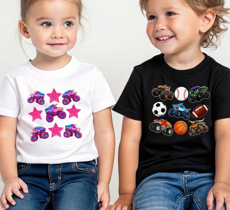 May include: Two children wearing t-shirts. One child wears a white t-shirt with a pattern of pink stars and monster truck unicorns. The other child wears a black t-shirt with a pattern of monster trucks, a baseball, a soccer ball, a basketball, and a football.