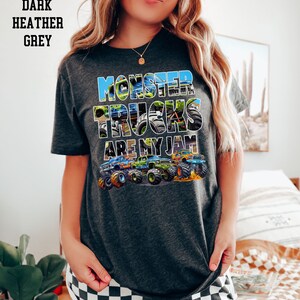 May include: Dark heather grey t-shirt with a graphic of monster trucks and the text "Monster Trucks Are My Jam".