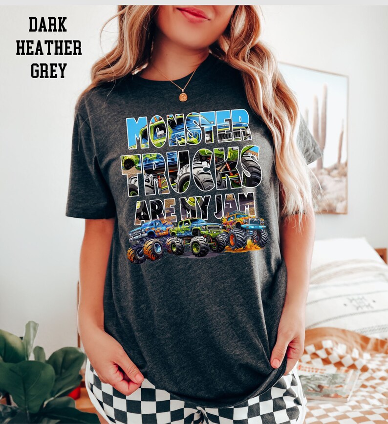 May include: Dark heather grey t-shirt with a graphic of monster trucks and the text "Monster Trucks Are My Jam".