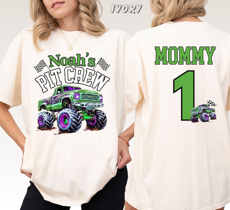 Pictured is a woman wearing a natural colored comfort colors t-shirt with a front back print design which says Noah's Pit Crew with a green and purple monster truck and 2 checkered flags on the front. On the back is custom name MOMMY and a custom number 1 and a small version of the truck
