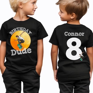 May include: Black t-shirt with a graphic of a person skateboarding and the text "Birthday Dude". The back of the shirt has the name "Connor" and the number "8" in white.