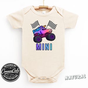 May include: A beige baby bodysuit with a colorful graphic of a unicorn monster truck and the word "MINI". The design includes checkered flags and the text "DESIGNED BY Common Code EST. 2020 FOR YOU AND YOUR CREW".