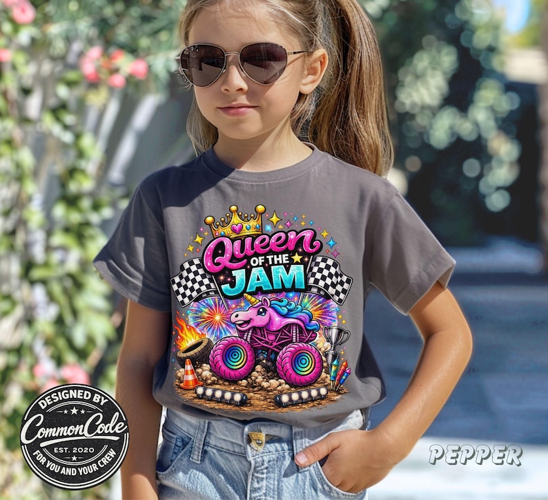 Peut inclure: T-shirt gris avec un motif color&eacute; d'un monster truck avec un design de licorne et le texte "Queen of the Jam". Le t-shirt pr&eacute;sente &eacute;galement des drapeaux &agrave; damier et le texte "Designed by Common Code EST. 2020 For You and Your Crew."