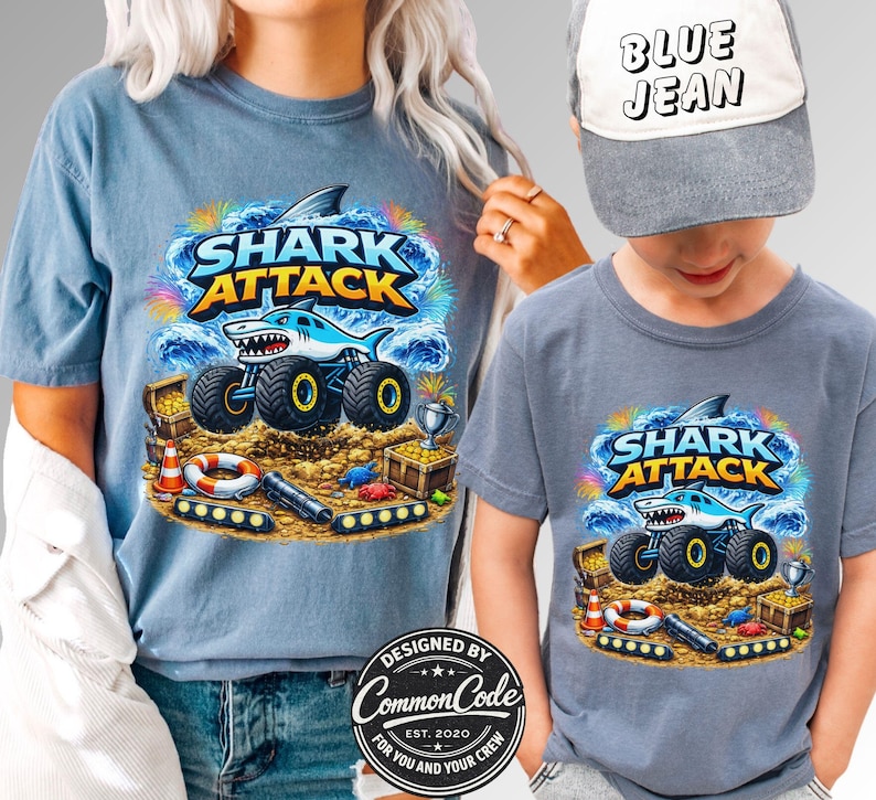 Pictured is a Mother and Son wearing blue t-shirts which sat SHARK ATTACK with a cartoon shark monster truck with beach nautical ocean background