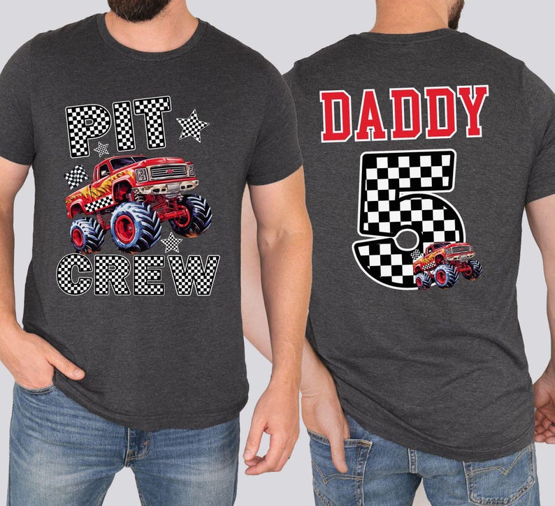 Op de afbeelding: Donkergrijze t-shirts met monster truck graphics. E&eacute;n shirt heeft "PIT CREW" en een rode monstertruck. De andere heeft "DADDY 5" met een monstertruck ontwerp. Beide zijn korte mouwen.