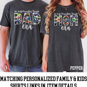Puede incluir: Dos camisetas grises con un gr&aacute;fico de camiones monstruo que deletrean "DAD" y "MOM" con el nombre "Ella" debajo. Las camisetas se muestran en dos personas.