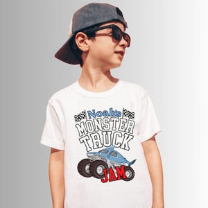 Puede incluir: Camiseta blanca con un gr&aacute;fico de monster truck. El dise&ntilde;o presenta un cami&oacute;n con tem&aacute;tica de tibur&oacute;n con el texto "Noah's MONSTER TRUCK JAM". La camiseta tiene cuello redondo y mangas cortas.