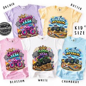 Peut inclure: Plusieurs t-shirts pour enfants de couleurs orchid&eacute;e, beurre, fleur, blanc et chambray. Chaque t-shirt pr&eacute;sente un motif de monster truck avec les textes "Queen of the Jam", "King of the Jam" ou "Shark Attack".