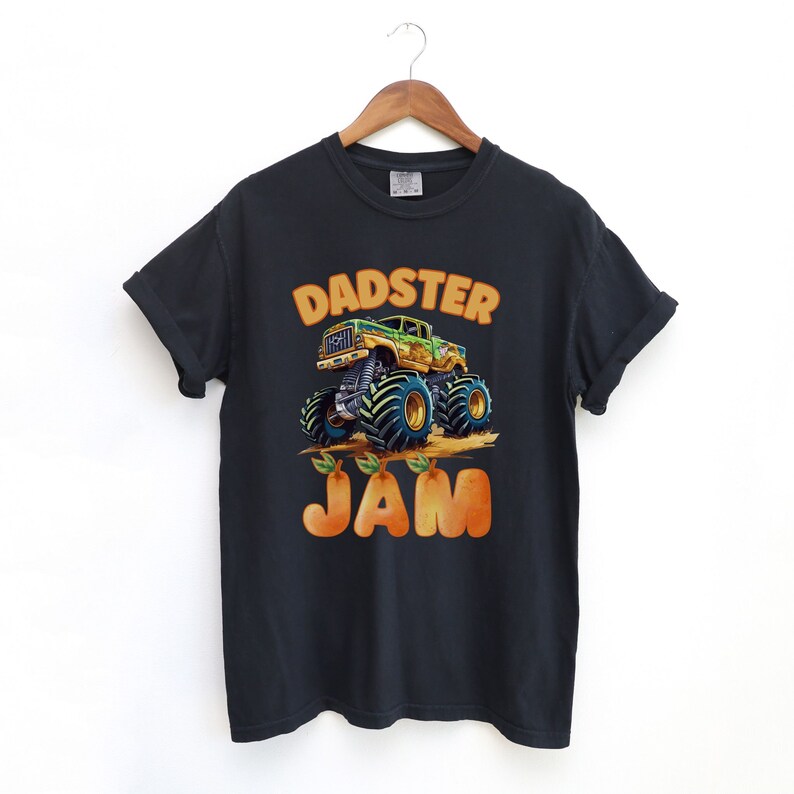 May include: Black t-shirt with a green and yellow monster truck graphic and the text "DADSTER JAM" in orange letters.