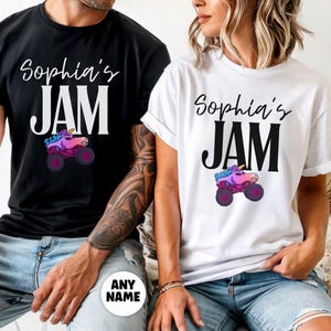 May include: Black and white t-shirts with the text "Sophia's JAM" in a script font. Below the text is a graphic of a monster truck with a unicorn head. The shirts are a casual style.