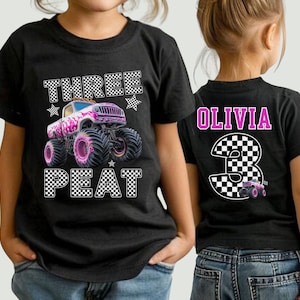Pictured is a young girl wearing a black t-shirt which says RHREE PEAT in black and white checkered letters along with a big pink monster truck and checkered stars. On the back of the tee is custom number 3 in black and white checkered and the custom name OLIVIA