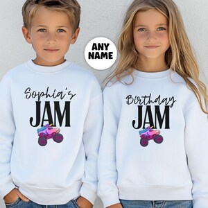 May include: White sweatshirts with black text that reads "Sophia's JAM" and "Birthday JAM". Each sweatshirt features a colorful monster truck graphic. The sweatshirts are designed for children and are suitable for birthday celebrations.