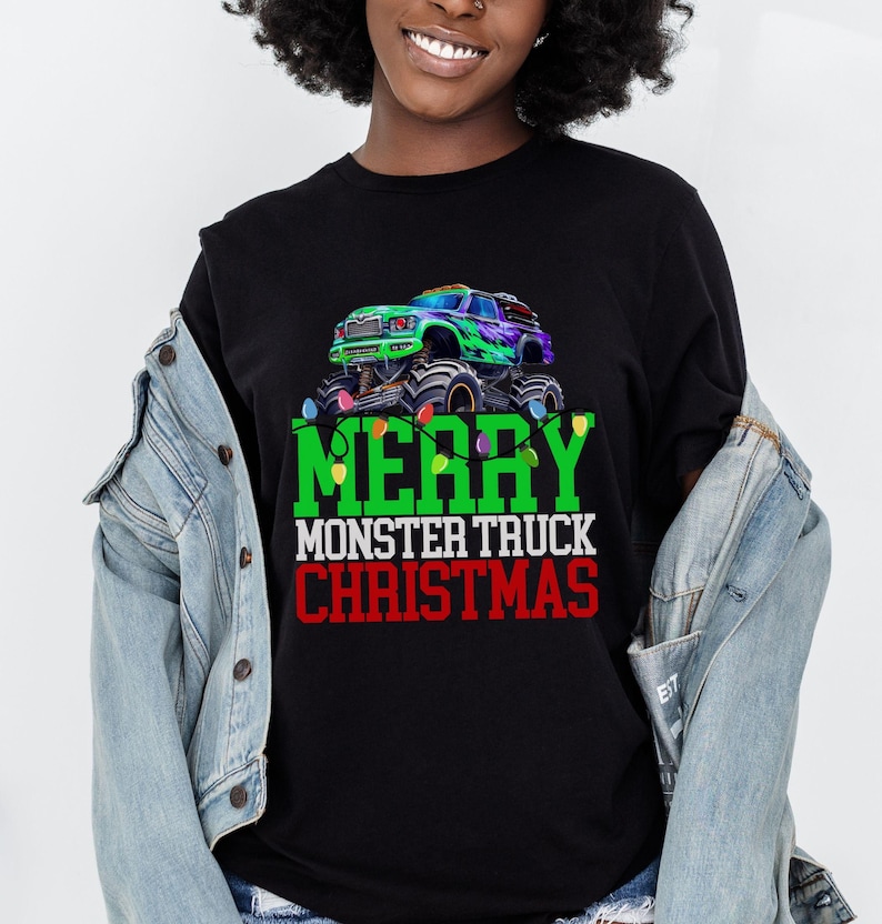 Puede incluir: Camiseta negra con un gr&aacute;fico de cami&oacute;n monstruo verde y el texto "Feliz Navidad del cami&oacute;n monstruo".