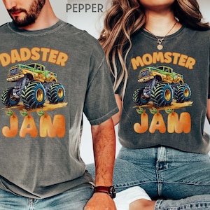 May include: A matching set of two gray t-shirts with a monster truck graphic and the text "DADSTER JAM" and "MOMSTER JAM". The monster truck is green, yellow, and black with orange wheels. The text is in orange.