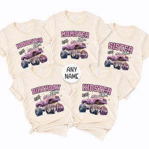 May include: Cream-coloured t-shirts with various designs. Each shirt features a monster truck graphic with the words "NANASTER JAM", "MOMSTER JAM", "SISTER JAM", "BIRTHDAY JAM", and "KIDSTER JAM". The shirts have a playful, family-themed design.