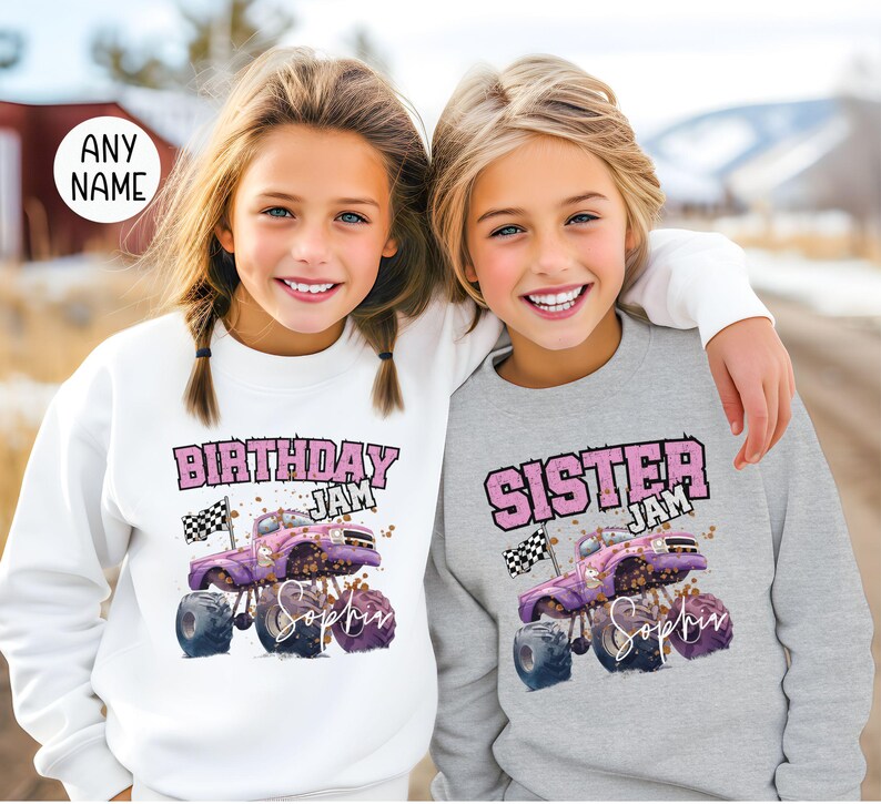 Pu&ograve; includere: Due ragazze indossano felpe abbinate con una grafica di un monster truck rosa. Una felpa dice "Birthday Jam" e l'altra dice "Sister Jam". Entrambe le felpe hanno il nome "Sophia" stampato su di esse.