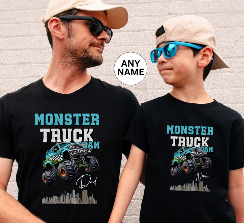 May include: Two black t-shirts featuring a monster truck graphic and the text "Monster Truck Jam". The larger shirt says "Dad" and the smaller shirt says "Noah".