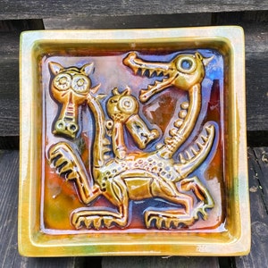 May include: White ceramic mug with a vibrant floral pattern. The mug has a handle and a broad rim. The flowers are in pinks, purples, and yellows. Suitable for hot or cold drinks.